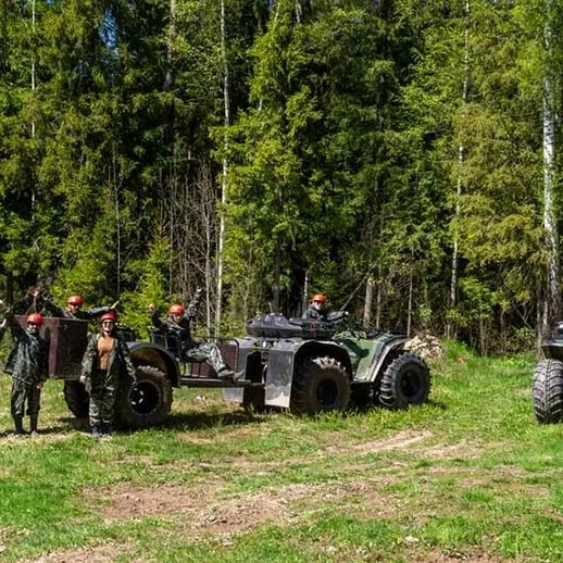 Группа людей на квадроциклах в лесу во время активного отдыха