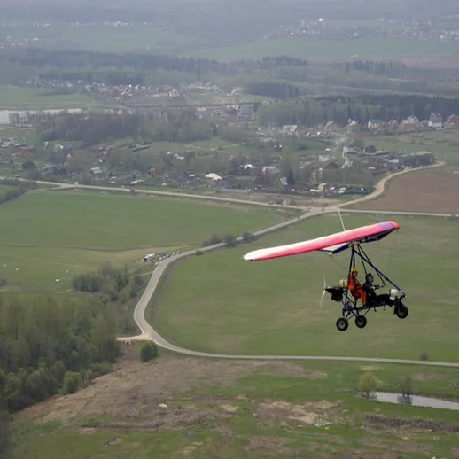 Полет на легком воздушном аппарате над живописными сельскими пейзажами в ясный день