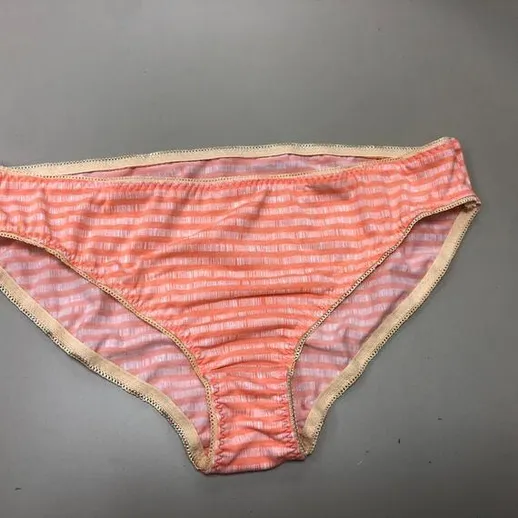 Плавки кораллового цвета с полосками на столе