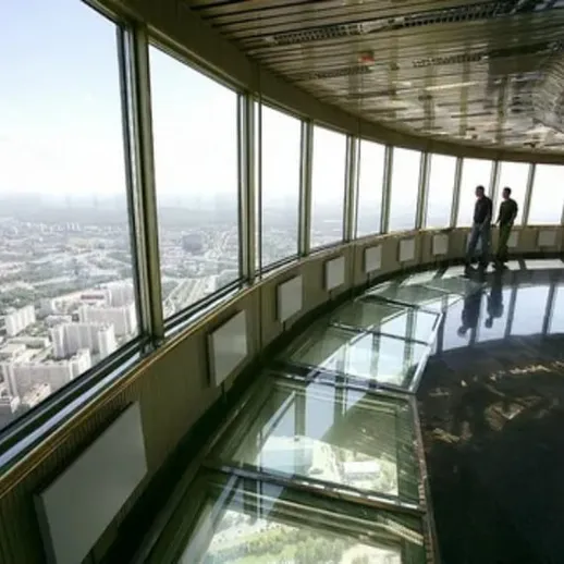 Посетители смотровой площадки на высоте в здании с панорамным видом на город в ясный день