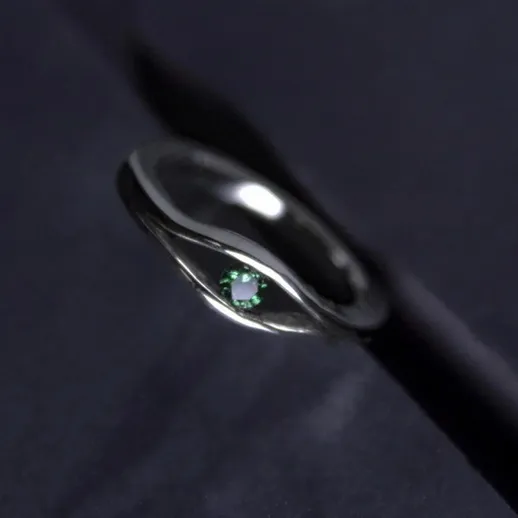 Крупный план капли воды на черной поверхности с отражением света в ней