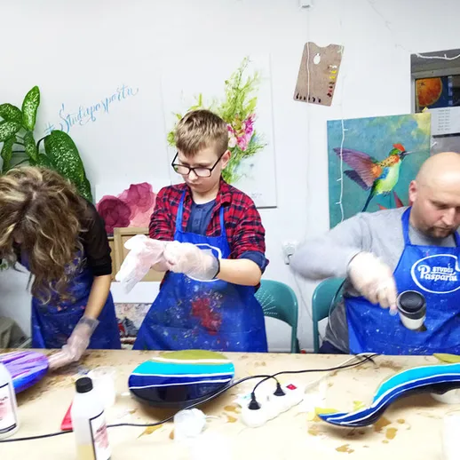 Участники мастер-класса по росписи деревянных предметов в студии в зимний вечер