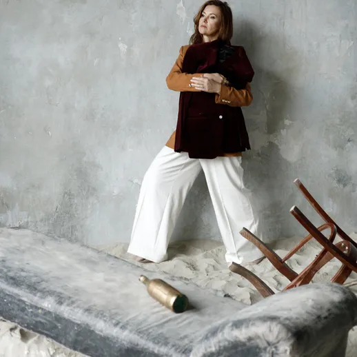 Женщина позирует в интерьере с нестандартной мебелью и аксессуарами в уникальном стиле