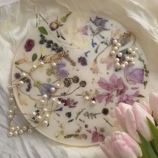 Украшения из жемчуга на фоне сушеных цветов и тюльпанов в нежных пастельных тонах