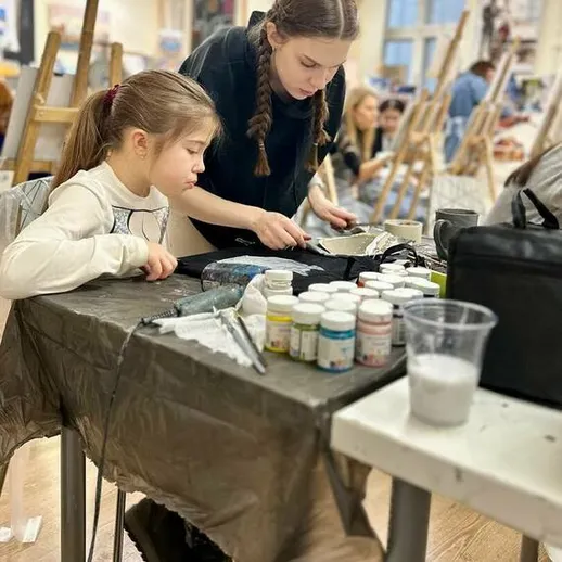 Две девушки занимаются живописью на уроке искусства в образовательном центре, осень