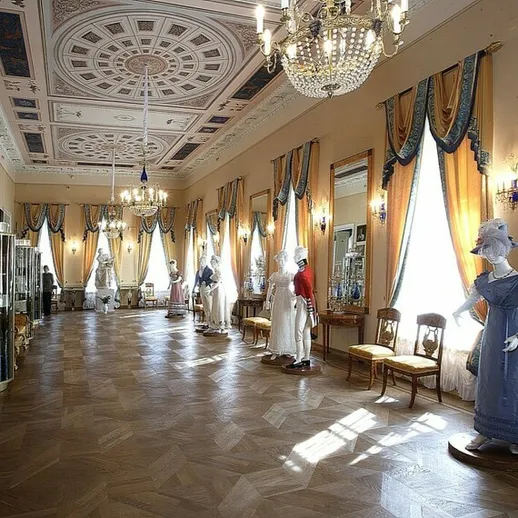 Исторический интерьер музея с выставкой платьев в солнечном свете