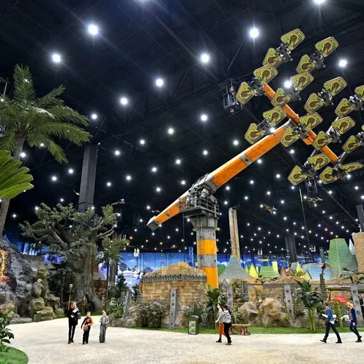 Аттракцион в крытом парке аттракционов с яркими огнями и растительностью для семейного отдыха