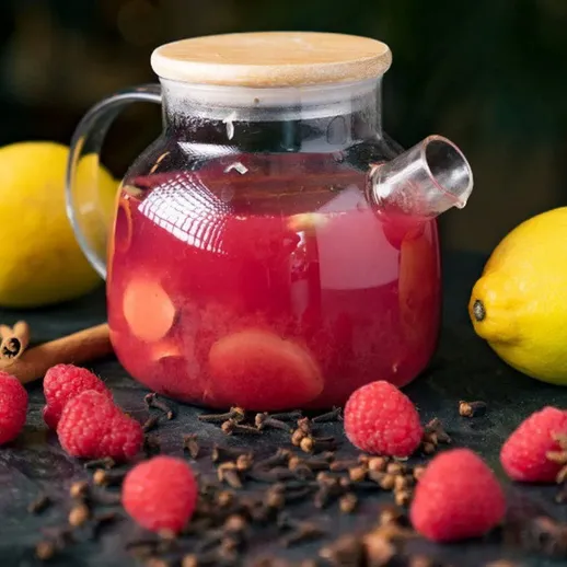 Вкусный малиновый напиток с лимоном и специями на темном фоне