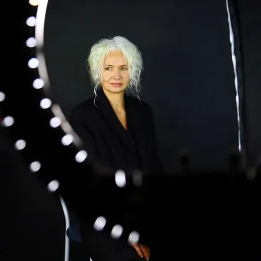 Портрет женщины с белыми волосами, сидящей перед зеркалом в студии