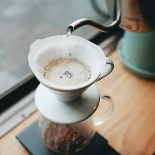 Процесс приготовления кофе с использованием фильтра в уютном кафе утром