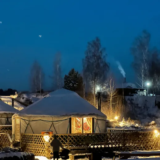 Уютная юрта под звездным небом на зимнем вечере в заснеженной местности