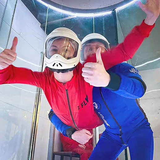 Люди в костюмах для парапланеризма наслаждаются свободным падением в аэродинамической трубе