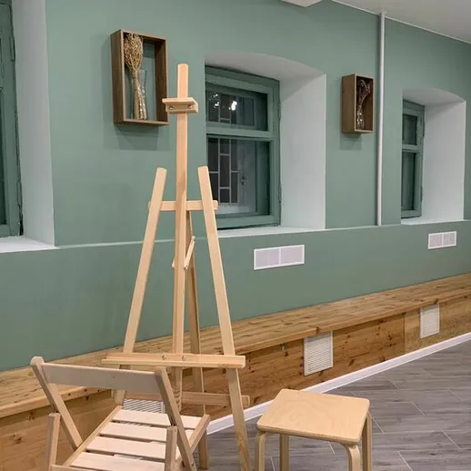 Красивый интерьер арт-студии с деревянными полками и мольбертом, расположенной в небольшом городе