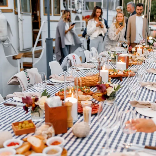 Уютный вечерний ужин на набережной с друзьми и вкусными угощениями, великолепные декорации и тёплая атмосфера