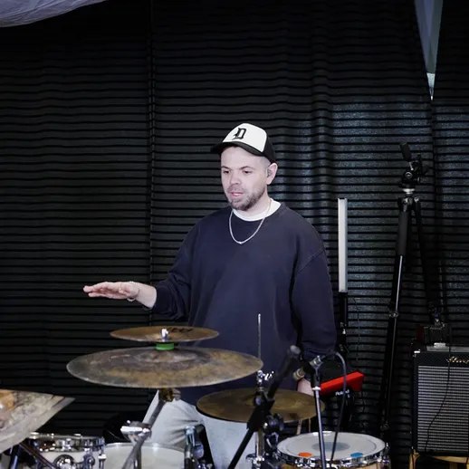 Музыканты на репетиции обсуждают характер звука ударных инструментов в студии записи