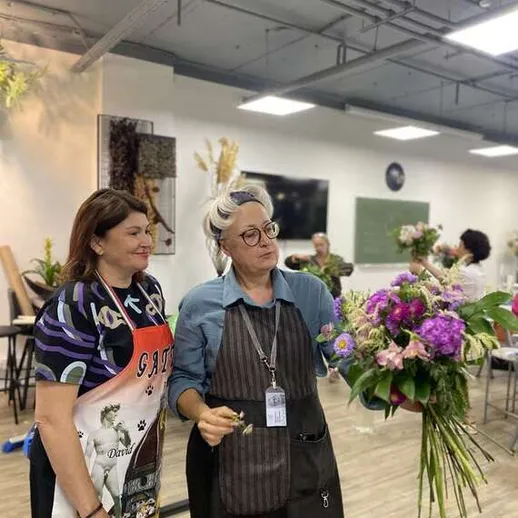 Женщины создают цветочные композиции на мастер-классе в цветочном магазине