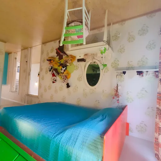 Уникальный интерьер комнаты с нестандартной мебелью и яркими цветами на фоне необычного дизайна стен