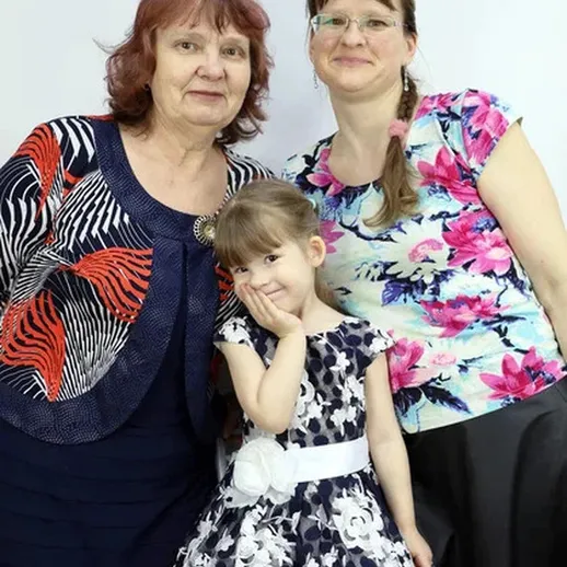 Младшая девочка позирует с двумя женщинами на празднике в уютном интерьере, веселье и радость в воздухе