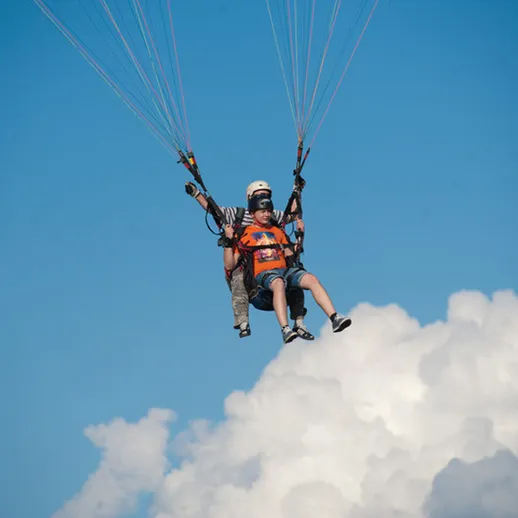Парапланеристы наслаждаются полетами над облаками в ясный день на курорте