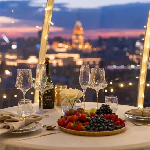 Уютный ужин при свечах с видом на вечерний город и освещенные здания