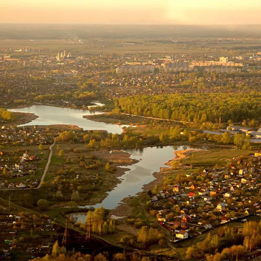 Панорама реки и города в солнечный вечер над живописным пейзажем загородной местности России
