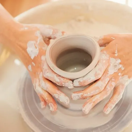 Лепка керамической чашки на гончарном круге в мастерской во время светлого дня