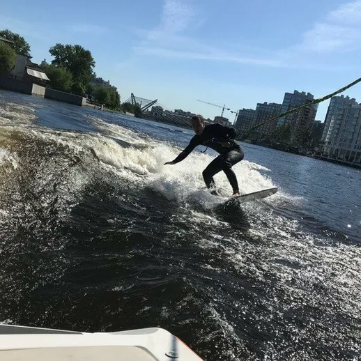 Серфер на водном лыжном канале в городе, наслаждающийся солнечным днем и легким ветром
