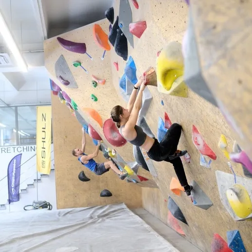 Скальные альпинисты на тренировочном стенде в Токио, занимающиеся боулдерингом в интерьере спортивного зала