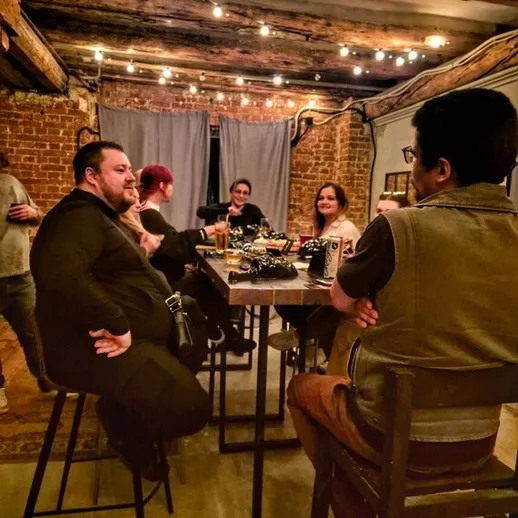 Вечерняя встреча друзей в уютном помещении с кирпичными стенами и мягким освещением