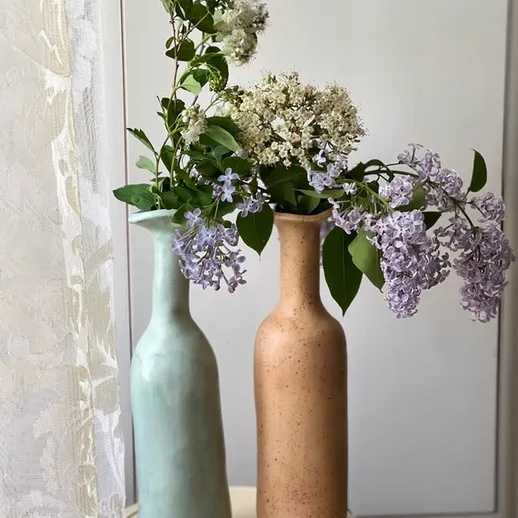 Две вазы с цветами на столе в интерьере, украшенном нежными оттенками, радуют глаз весной