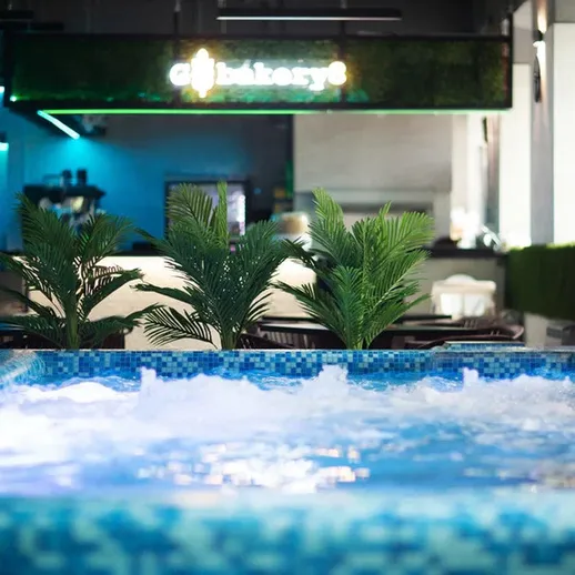 В ресторане с бассейном и зелеными растениями в вечернее время