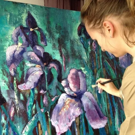 Художница создает картину с ирисами в ярких цветах в своей студии