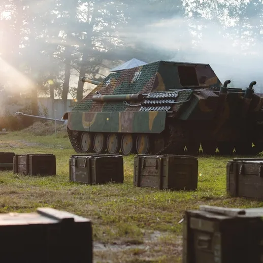 Немецкий танк на военном учении на открытом воздухе в лесу под вечерним светом