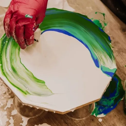 Создание акриловой росписи на круглой поверхности с использованием зеленых и голубых тонов в мастерской для художественного творчества