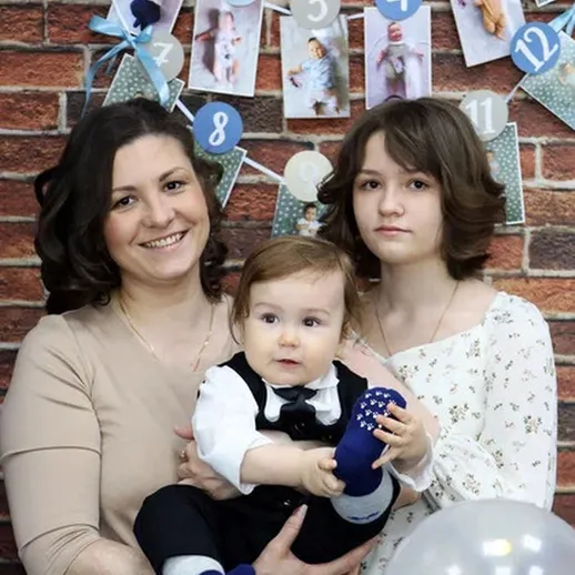 Празднование дня рождения с детьми и мамой на фоне украшений и фотографий