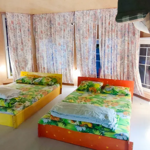 Яркая комната для отдыха с натуральным освещением и уютными кроватями в кафе