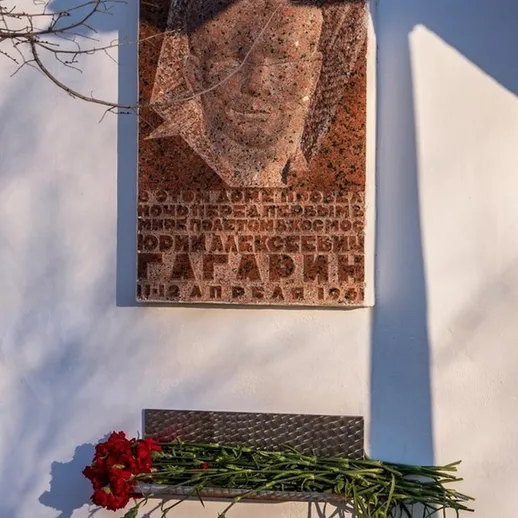 Памятник Юрию Гагарину на стене в городе, окруженном цветами возле мемориала