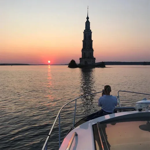 Закат над водами, яхта у острова с башней на фоне, тихий вечер на реке