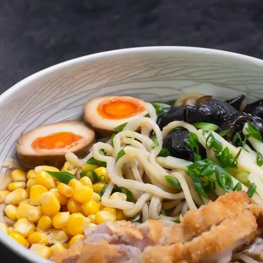 Ароматный мисо рамен с курицей и яйцом, поданный в уютном ресторане японской кухни в вечернее время