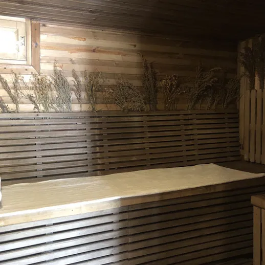 Традиционная русская баня с сосновыми полками и травами на стенах, обустроенная для отдыха и релаксации