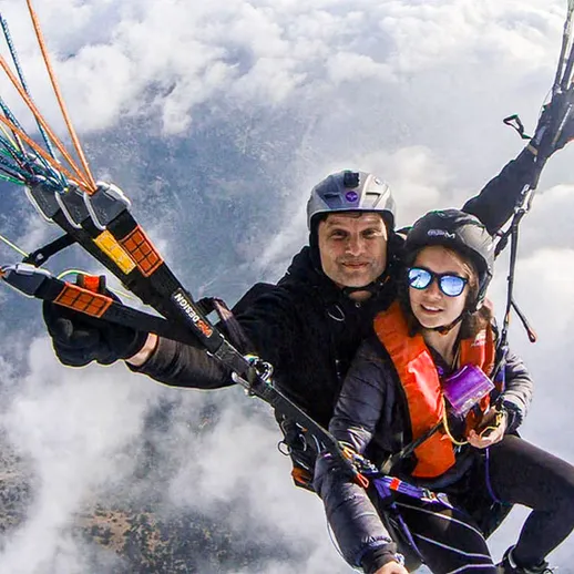 Парапланеры летают над облаками, наслаждаясь живописным видом на горы и природу в осенний день