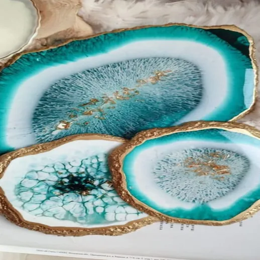 Элегантные подносы из смолы с уникальным дизайном в бирюзовых тонах на фоне мягкого текстиля