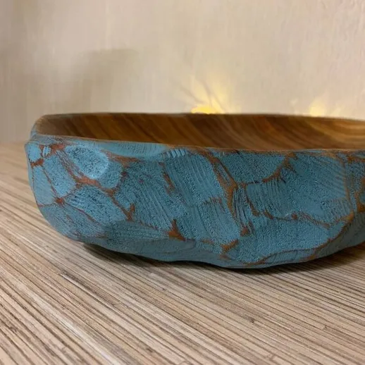 Чаша с уникальным окрашенным узором на деревянной столешнице в уютном интерьере