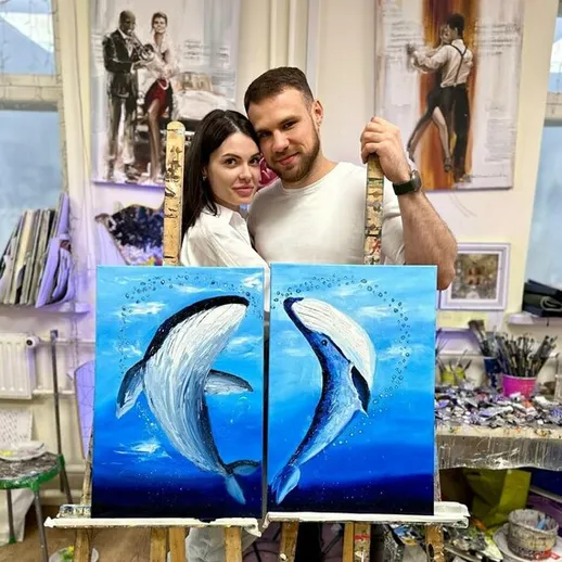 Пара художников с картинами дельфинов на уроке живописи в творческой студии