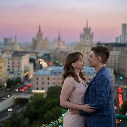 Романтический момент пары на крыше в центре Москвы на фоне заката