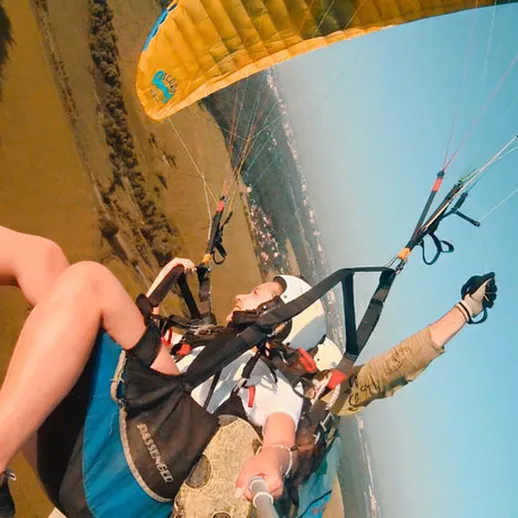 Полет на параплане над живописным холмистым ландшафтом в ясный день