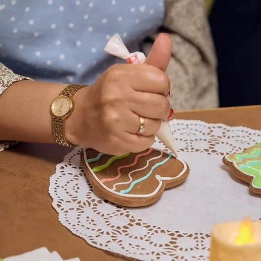 Процесс украшения пряников на кухне во время праздников с использованием разноцветной глазури