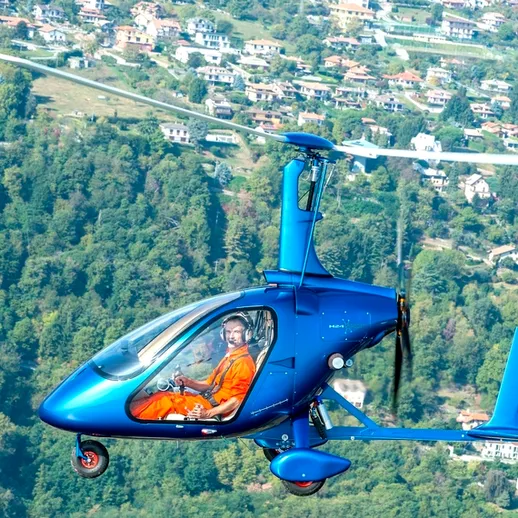 Полёт на гироплане над зелёными холмами и городскими пейзажами в солнечный день