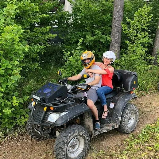 Пара катится на квадроцикле по лесной тропинке в солнечный день, наслаждаясь активным отдыхом на природе