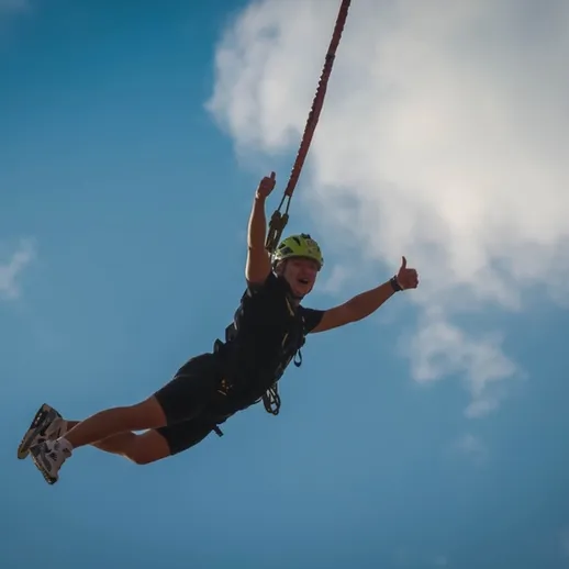 Занимательный момент: человек, летающий на тросе над живописным пейзажем в солнечный день